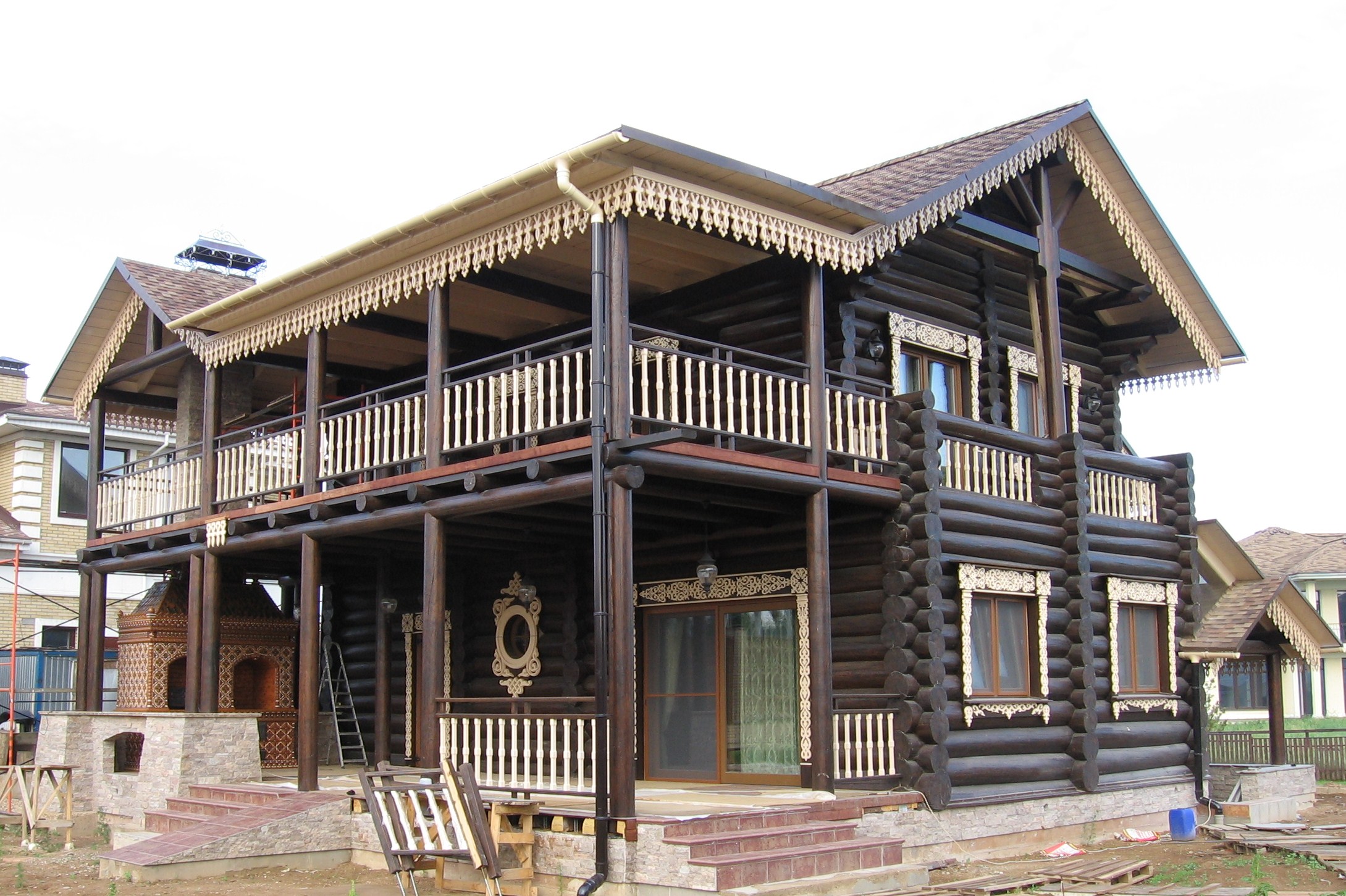 Резные деревянные наличники на коричневом фасаде