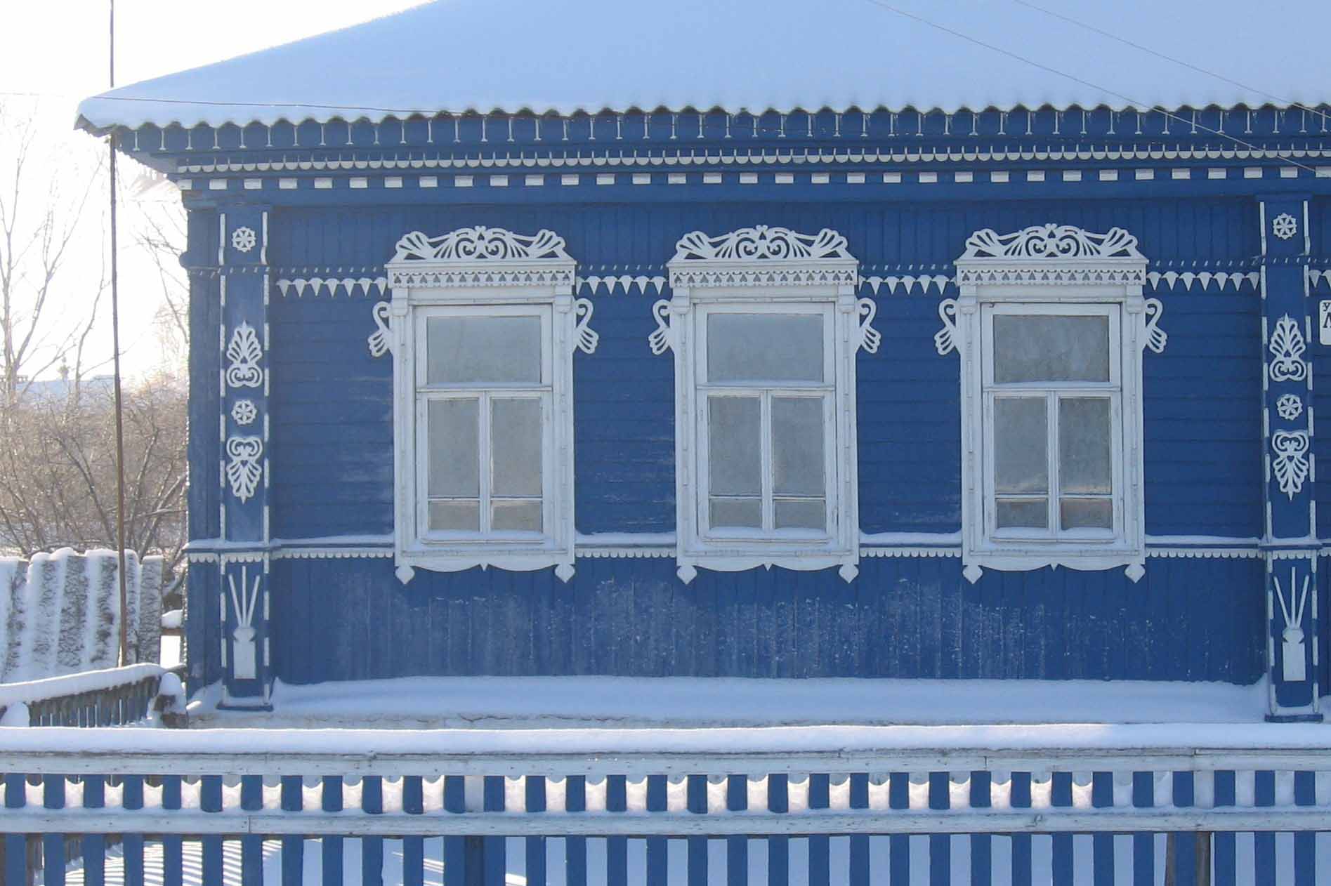 Восстановленный фасад деревенского дома украшенного домовой резьбой